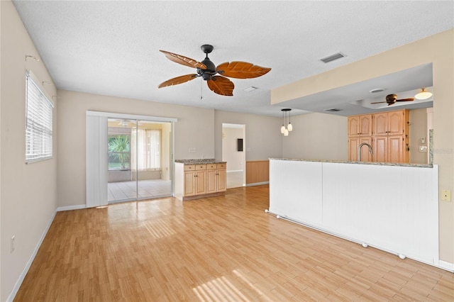 8130 SW 209th Court Rd, Dunnellon, FL 34431 - unfurnished living room with ceiling fan, baseboards, light wood-style flooring, and a textured ceiling