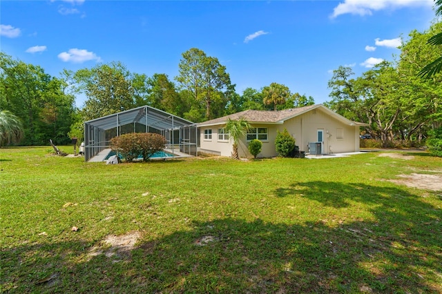 8130 SW 209th Court Rd, Dunnellon, FL 34431 - rear view of property featuring a lawn, an outdoor pool, glass enclosure, and cooling unit