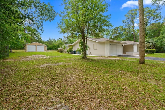 8130 SW 209th Court Rd, Dunnellon, FL 34431 - view of side of home featuring a yard, a detached garage, and stucco siding