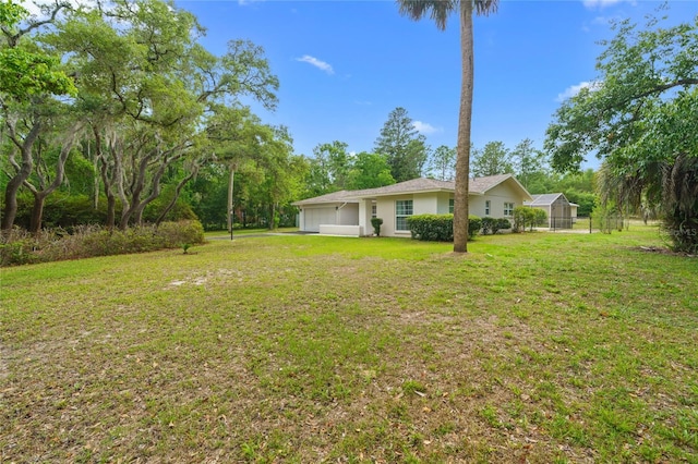 8130 SW 209th Court Rd, Dunnellon, FL 34431 - view of grassy yard with an attached garage and view of wooded area