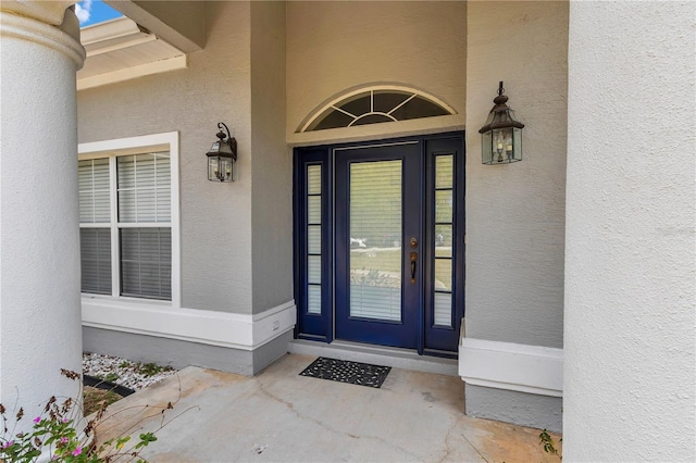 doorway to property featuring stucco siding