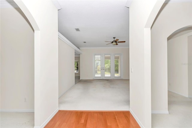 interior space with visible vents, ornamental molding, baseboards, ceiling fan, and french doors