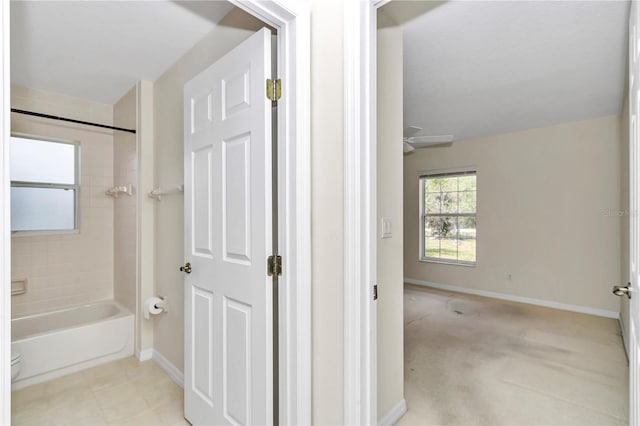 full bath featuring baseboards, bathtub / shower combination, and toilet