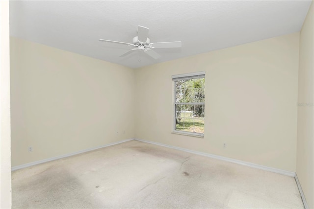 empty room featuring a ceiling fan, baseboards, and carpet