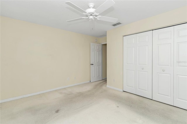 unfurnished bedroom featuring light carpet, a ceiling fan, baseboards, visible vents, and a closet