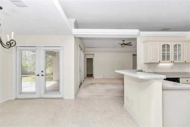 kitchen featuring ceiling fan, visible vents, light countertops, baseboards, and glass insert cabinets
