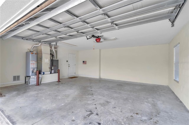 garage with visible vents, a garage door opener, and water heater