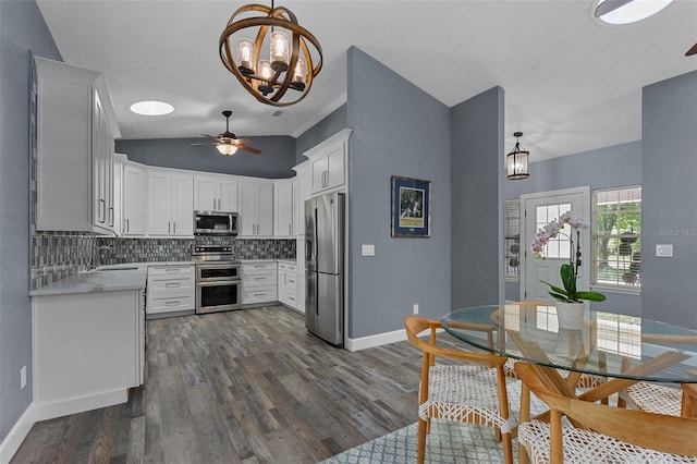 260 Country Circle Dr W, Port Orange, FL 32128 - kitchen with stainless steel appliances, ceiling fan with notable chandelier, decorative backsplash, dark wood-style floors, and light countertops