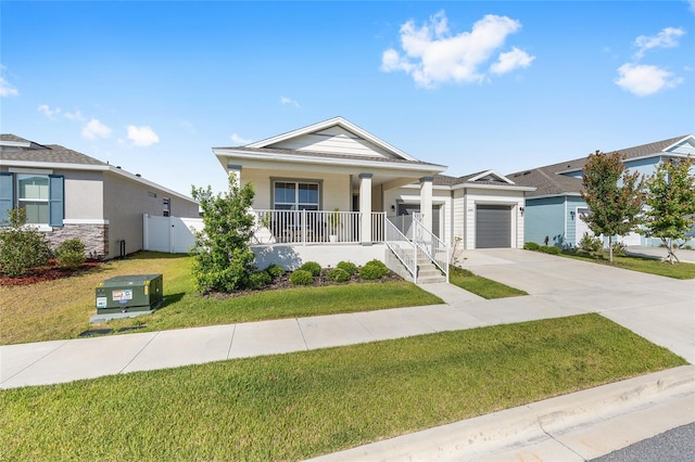 6342 SW 77th Ave, Ocala, FL 34474 - view of front facade with covered porch, an attached garage, fence, concrete driveway, and a front lawn
