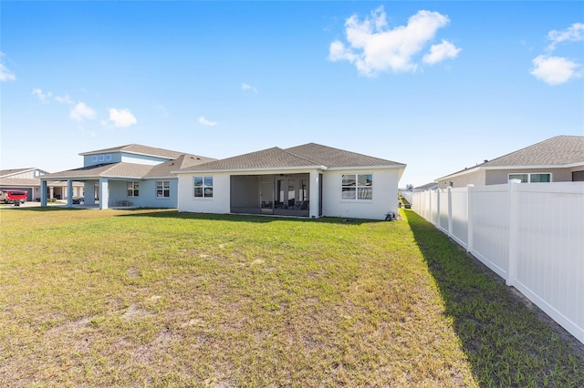6342 SW 77th Ave, Ocala, FL 34474 - rear view of property featuring roof with shingles, fence, stucco siding, a lawn, and a sunroom