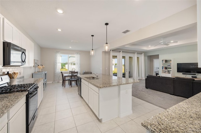 6342 SW 77th Ave, Ocala, FL 34474 - kitchen featuring light stone countertops, light tile patterned floors, a sink, white cabinetry, and black appliances