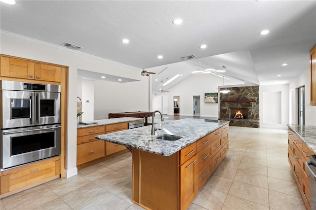 170 SW 80th St, Ocala, FL 34476 - kitchen with stainless steel double oven, a sink, open floor plan, a stone fireplace, and ornamental molding