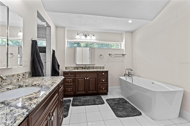 170 SW 80th St, Ocala, FL 34476 - full bathroom with a freestanding bath, two vanities, tile patterned floors, baseboards, and a textured ceiling