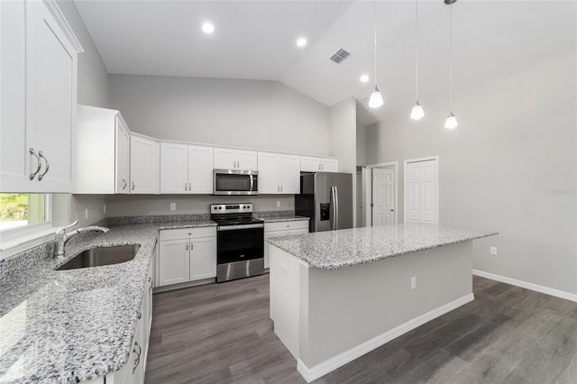 kitchen with appliances with stainless steel finishes, a sink, high vaulted ceiling, a center island, and white cabinets