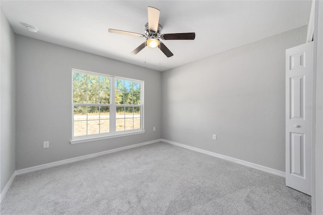 unfurnished room with carpet, a ceiling fan, and baseboards