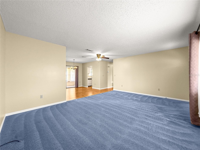 6263 SW 107th St, Ocala, FL 34476 - carpeted spare room with a textured ceiling, visible vents, baseboards, and ceiling fan with notable chandelier
