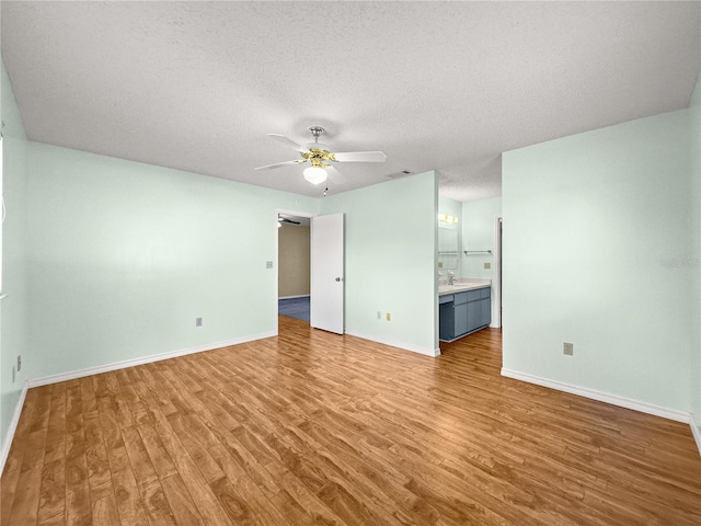 6263 SW 107th St, Ocala, FL 34476 - unfurnished living room featuring a ceiling fan, light wood-type flooring, visible vents, baseboards, and a textured ceiling