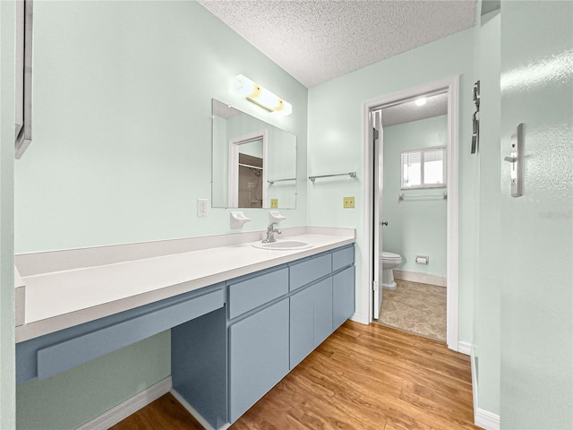 6263 SW 107th St, Ocala, FL 34476 - bathroom featuring toilet, wood finished floors, a textured ceiling, baseboards, and vanity