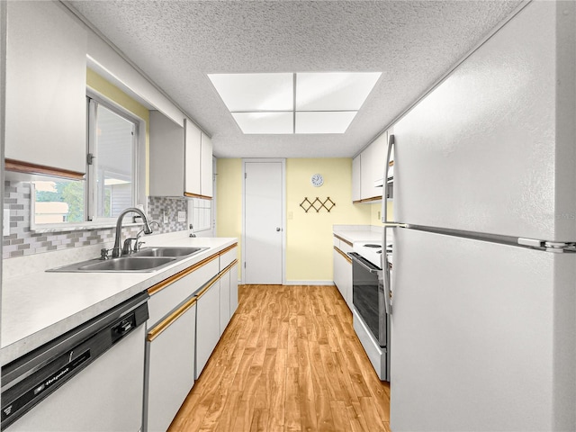 6263 SW 107th St, Ocala, FL 34476 - kitchen with white appliances, a sink, decorative backsplash, light wood-style floors, and light countertops