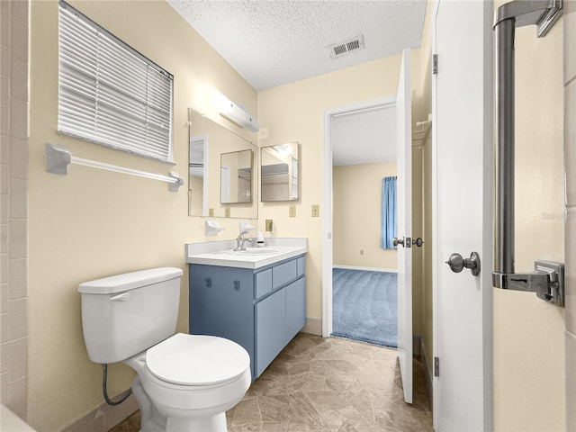 6263 SW 107th St, Ocala, FL 34476 - bathroom featuring toilet, a textured ceiling, visible vents, baseboards, and vanity