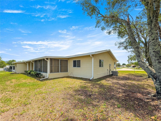 6263 SW 107th St, Ocala, FL 34476 - back of property with a lawn, central AC, and a sunroom