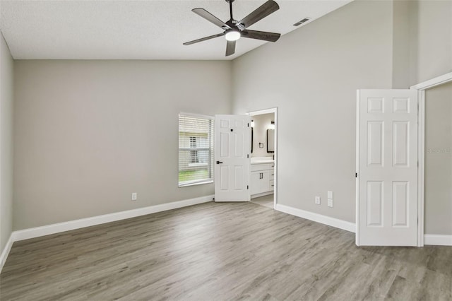 1317 Ravida Woods Dr, Apopka, FL 32703 - unfurnished bedroom featuring high vaulted ceiling, light wood-type flooring, baseboards, connected bathroom, and a ceiling fan