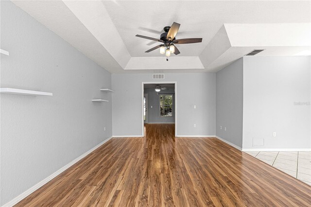 6758 SW 114th Street Rd, Ocala, FL 34476 - unfurnished living room with visible vents, wood finished floors, a raised ceiling, and ceiling fan