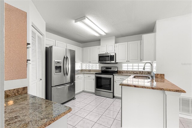 6758 SW 114th Street Rd, Ocala, FL 34476 - kitchen featuring a peninsula, a sink, stainless steel appliances, visible vents, and light tile patterned flooring