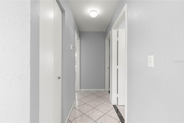 6758 SW 114th Street Rd, Ocala, FL 34476 - hall featuring a textured ceiling, baseboards, and light tile patterned floors