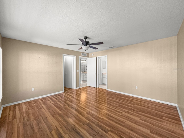 6758 SW 114th Street Rd, Ocala, FL 34476 - unfurnished bedroom featuring ensuite bathroom, wood finished floors, a textured ceiling, ceiling fan, and baseboards