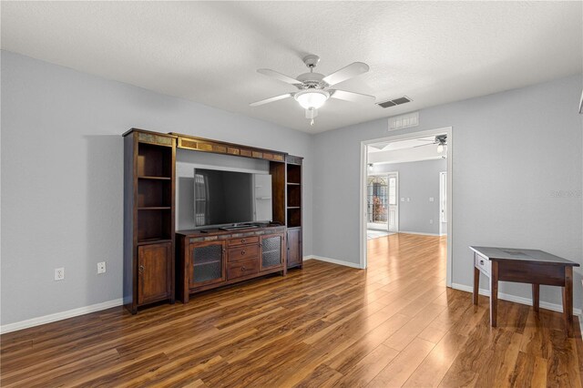 6758 SW 114th Street Rd, Ocala, FL 34476 - unfurnished living room with wood finished floors, a textured ceiling, visible vents, ceiling fan, and baseboards