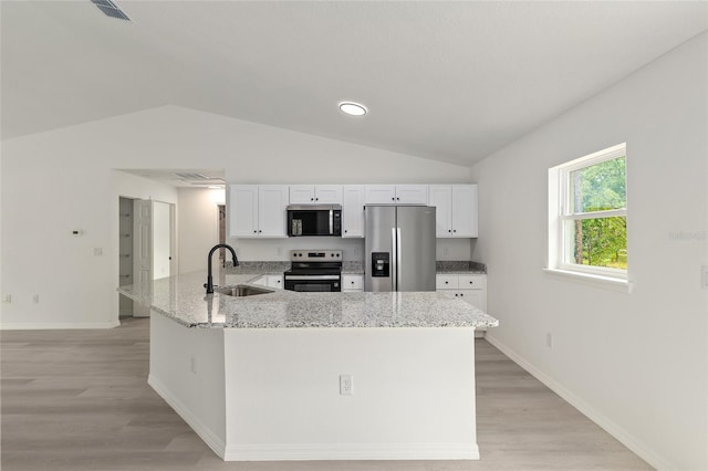 23131 SW Rainelle Rd, Dunnellon, FL 34431 - kitchen featuring appliances with stainless steel finishes, a sink, lofted ceiling, white cabinetry, and light stone countertops
