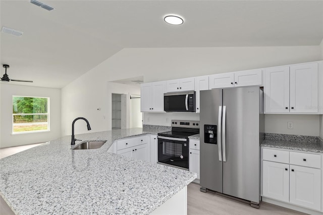 23131 SW Rainelle Rd, Dunnellon, FL 34431 - kitchen featuring stainless steel appliances, a sink, lofted ceiling, a peninsula, and white cabinets