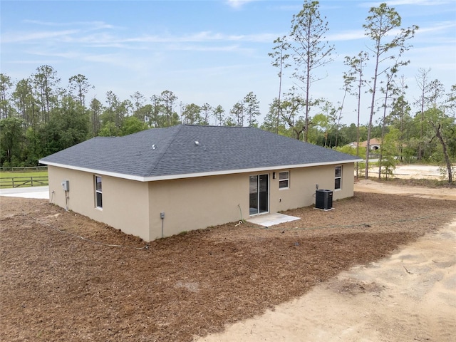 23131 SW Rainelle Rd, Dunnellon, FL 34431 - rear view of property featuring stucco siding, a shingled roof, fence, and view of wooded area