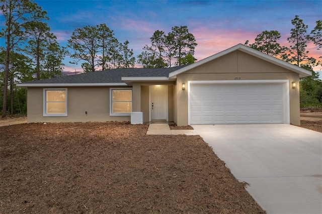 23131 SW Rainelle Rd, Dunnellon, FL 34431 - ranch-style house with stucco siding, driveway, an attached garage, and roof with shingles