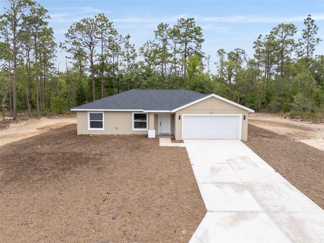 23131 SW Rainelle Rd, Dunnellon, FL 34431 - single story home featuring a garage, driveway, stucco siding, and a shingled roof