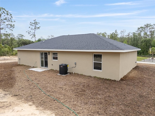 23131 SW Rainelle Rd, Dunnellon, FL 34431 - rear view of property featuring stucco siding, cooling unit, roof with shingles, and fence