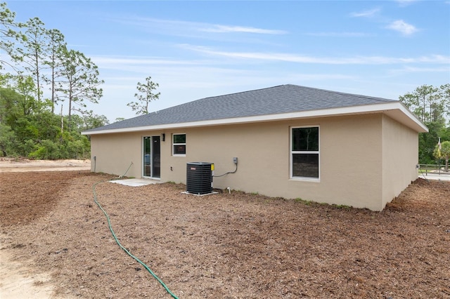 23131 SW Rainelle Rd, Dunnellon, FL 34431 - back of property featuring stucco siding, cooling unit, and a shingled roof