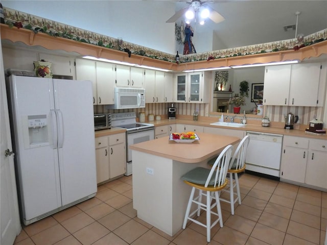kitchen featuring a sink, white appliances, visible vents, light countertops, and light tile patterned floors