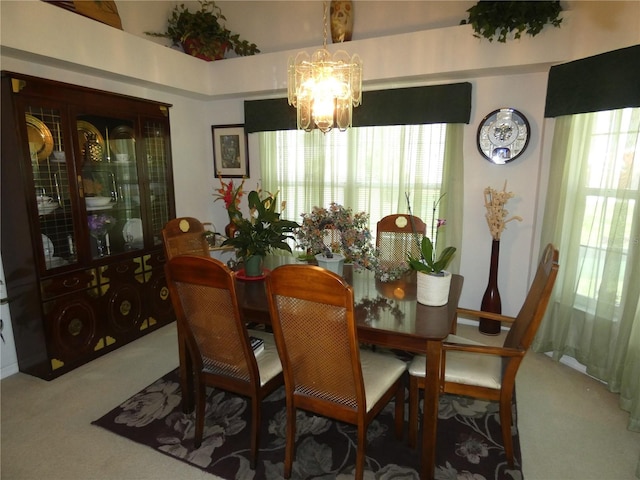 carpeted dining room featuring a chandelier and a healthy amount of sunlight