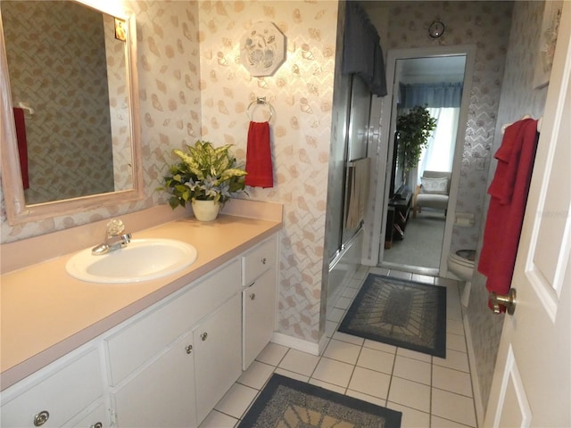 full bathroom featuring tile patterned floors, wallpapered walls, toilet, and vanity