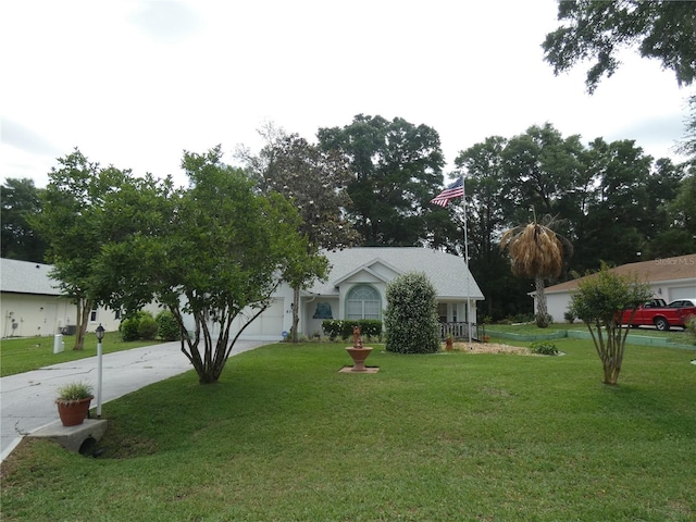view of front of house with concrete driveway, a front yard, and a garage
