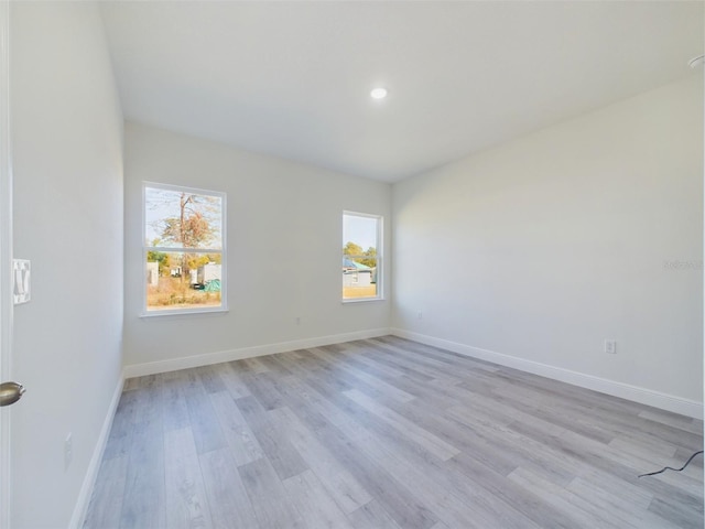 spare room featuring baseboards, light wood-style flooring, and recessed lighting