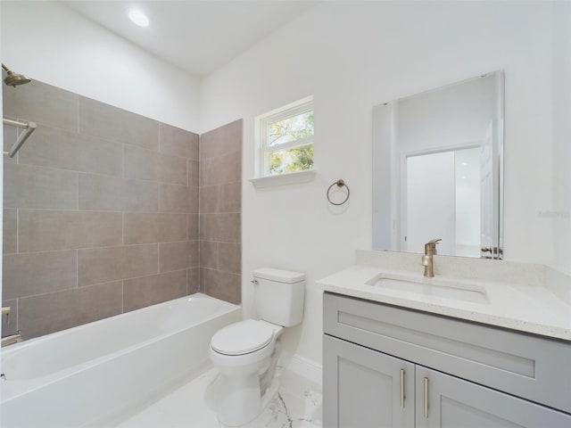 bathroom featuring toilet, marble finish floor, baseboards, vanity, and bathtub / shower combination