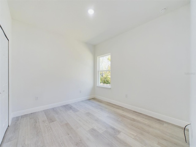 spare room with light wood-style floors, baseboards, and recessed lighting