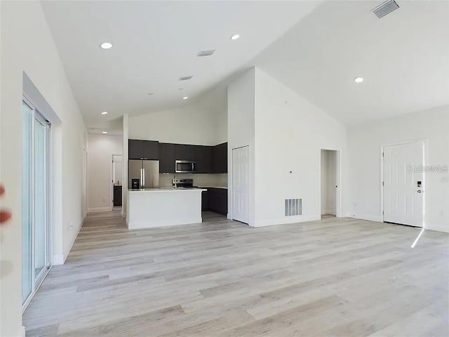 4415 SW 169th Lane Rd, Ocala, FL 34473 - unfurnished living room with light wood finished floors, visible vents, and high vaulted ceiling