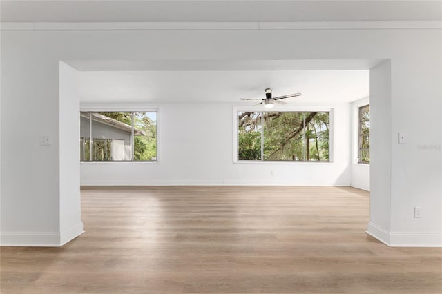 unfurnished room with wood finished floors, baseboards, and ceiling fan