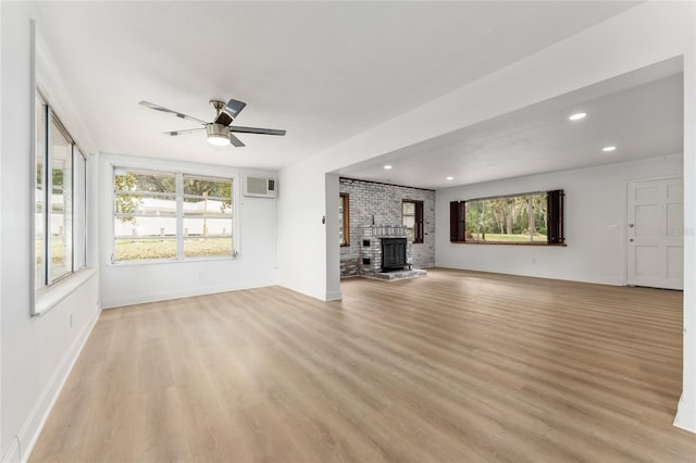 unfurnished living room featuring a wall mounted air conditioner, recessed lighting, light wood finished floors, a ceiling fan, and baseboards
