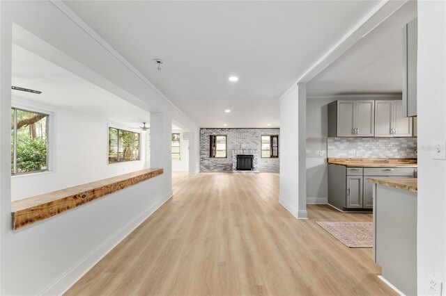 hall featuring light wood-style flooring, baseboards, and recessed lighting