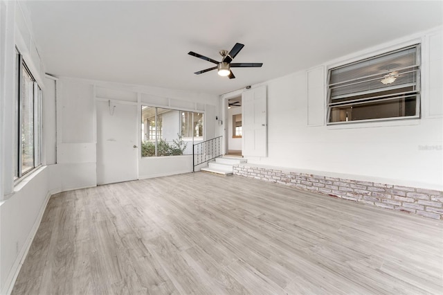 unfurnished living room with a ceiling fan, a healthy amount of sunlight, and wood finished floors